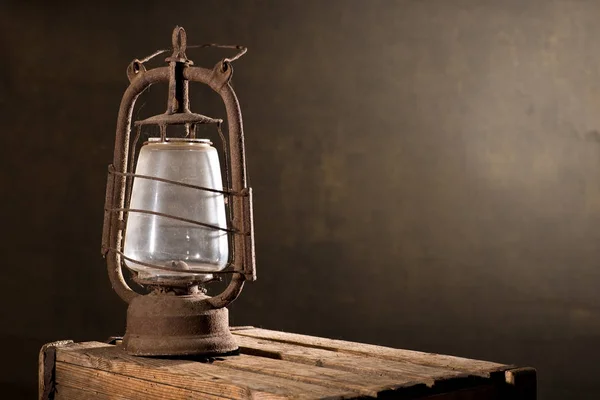 Velha lanterna enferrujada na mesa de madeira no sótão — Fotografia de Stock