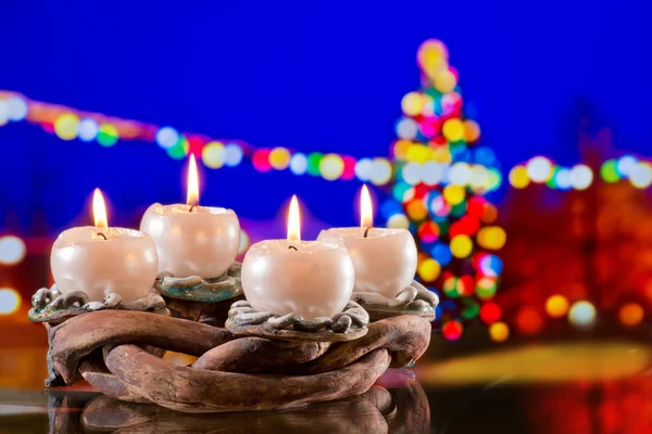 Венок с горящими свечами перед рождественской елкой — стоковое фото