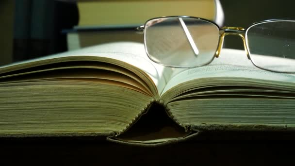 メガネ使用のテーブルの上で本を開きます スライディング — ストック動画