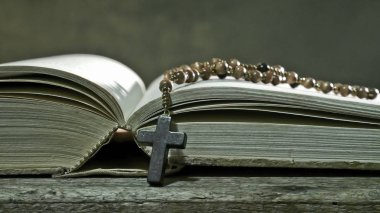 Eski masada Rosary ile açık kitap 