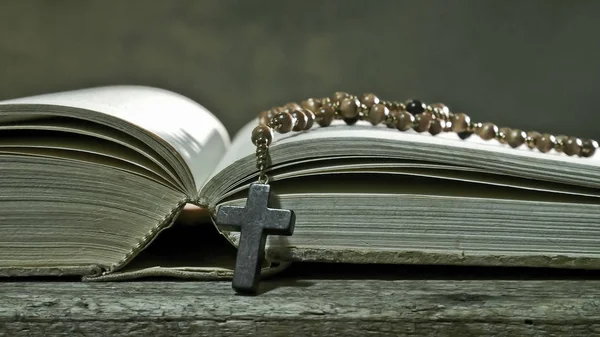 Libro abierto con rosario en la mesa antigua — Foto de Stock