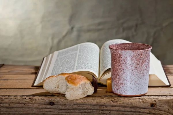 Bible, kalich a chléb na dřevěné desce. — Stock fotografie