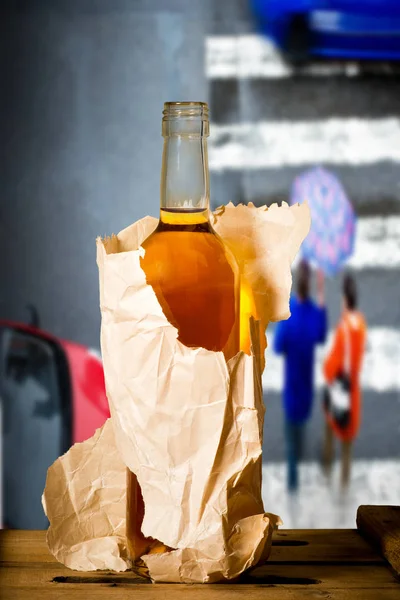 Glass of spirits in the paper bag in the street — Stock Photo, Image