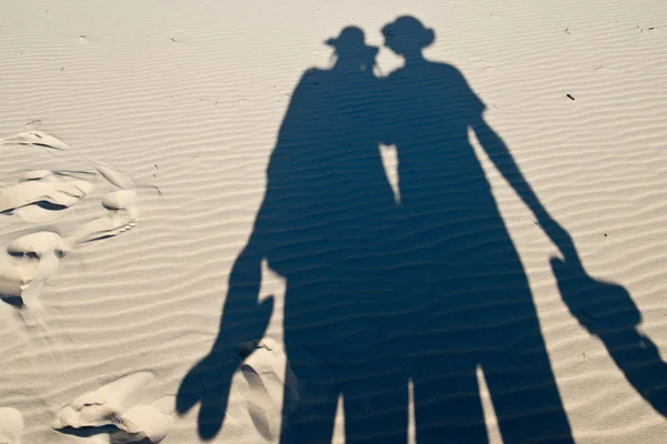 Shadows of pair of tourists on sand dunes — Stock Photo, Image