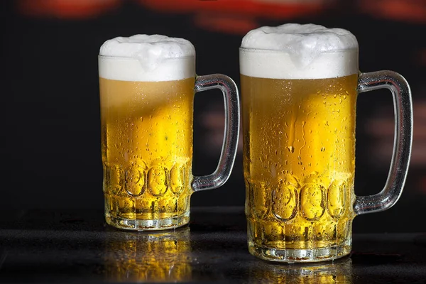 Zwei Gläser Bier auf dunklem Hintergrund Stockfoto