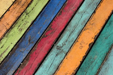 Wood planks painted with paint cracked by a rustic background. Wooden texture in multicolor paint. Color wood background textures. Color wood background textures. Blue, green, yellow,orange,pink
