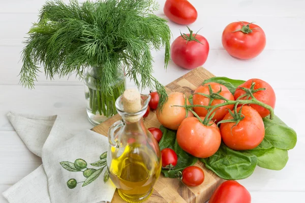 Aceite de oliva, perejil, espinacas y rama de tomate sobre fondo blanco — Foto de Stock