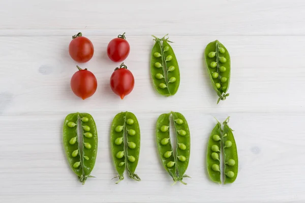 Vainas abiertas de guisantes y tomates cherry — Foto de Stock