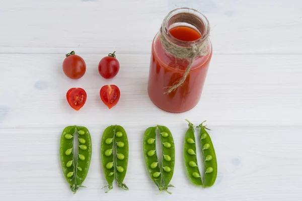 Vainas abiertas de guisantes, tomates cherry y jugo de tomate — Foto de Stock