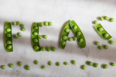 Beyaz mermer üzerinde açık bakla yeşil bezelye