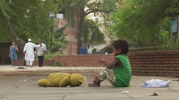 Delhi, India - szeptember 29, 2016: Szegénység Indiában. Egy hajléktalan kislány játszik a járdán — Stock videók