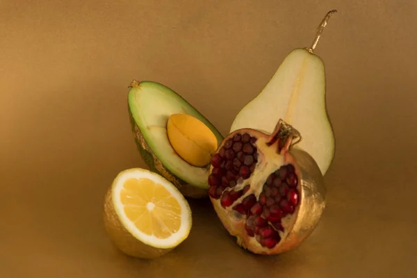 Goldene Fruchtmischung Aus Birne Avocado Granatfrucht Zitrone Auf Goldenem Hintergrund — Stockfoto