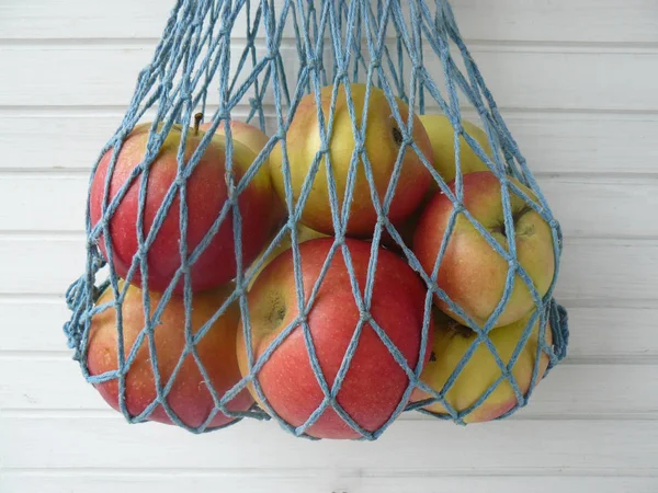 red apple in mesh bag - Stock Image