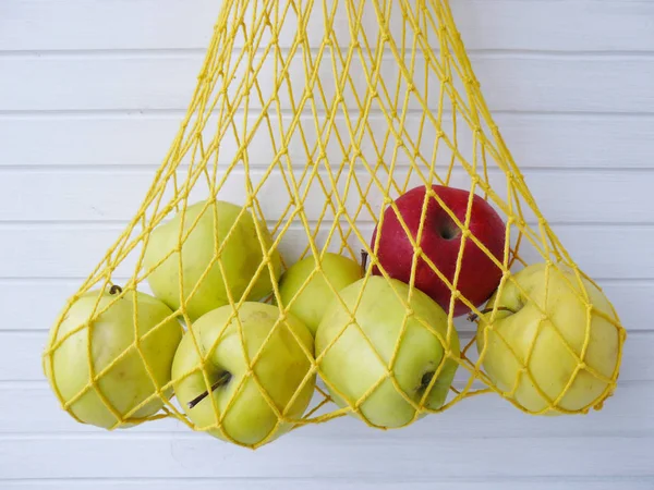 stock image Yellow and red apple in mesh bag - Stock Image