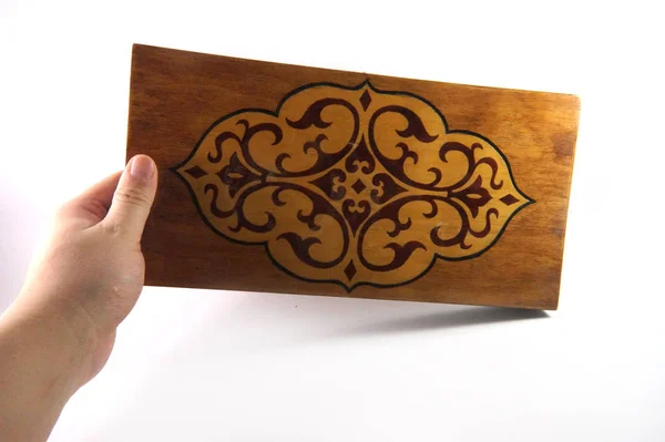 Wooden board, drawing on the board, Openwork pattern, Openwork pattern, Pattern on the blackboard, Brown, Beige, Beige shades, Covered box, Closed board, Wooden, Board in hand, Hand, Headstock stock image