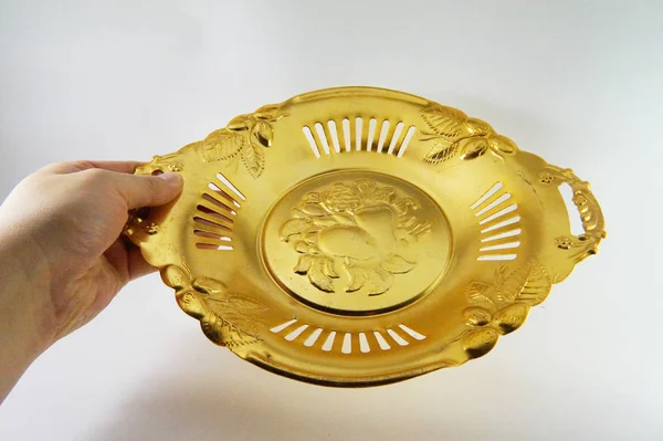 Plate in hand, tray in hand, saucer in hand, hand, Antique gold plate, vintage plate, golden dish, golden saucer, gold color, gold on white, close-up, white background, Soviet antiquarian, USSR, old plate, shabby,  headstock stock image, Nostalgishop