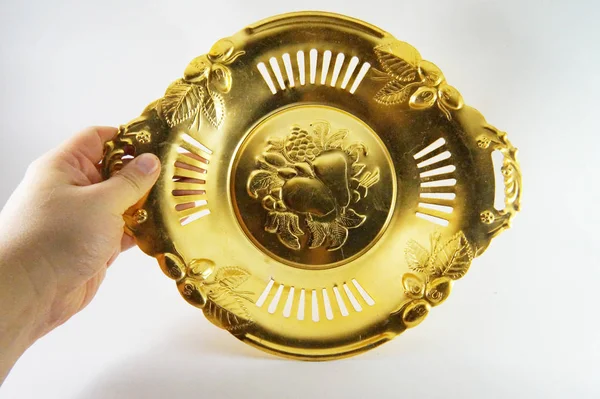 Plate in hand, tray in hand, saucer in hand, hand,  Antique gold plate, vintage plate, golden dish, golden saucer, gold color, gold on white, close-up, white background, Soviet antiquarian, USSR, old plate, shabby, headstock stock image, Nostalgishop