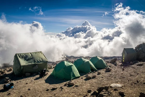 İnsanlar Kilimanjaro Dağı trekking için bulutlar üzerinde çadır — Stok fotoğraf
