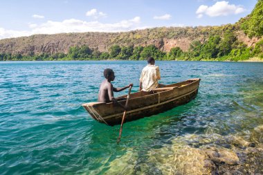 Africans in canoe on beautiful Chala lake, Kenya and Tanzania bo clipart