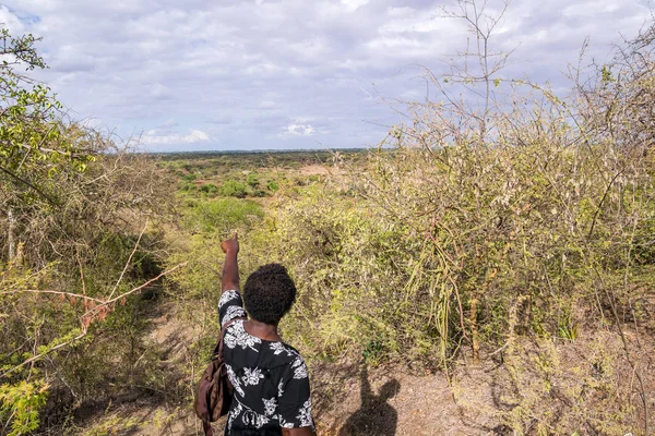 Африканская женщина указывает вперед на неразвитую сельскую местность — стоковое фото
