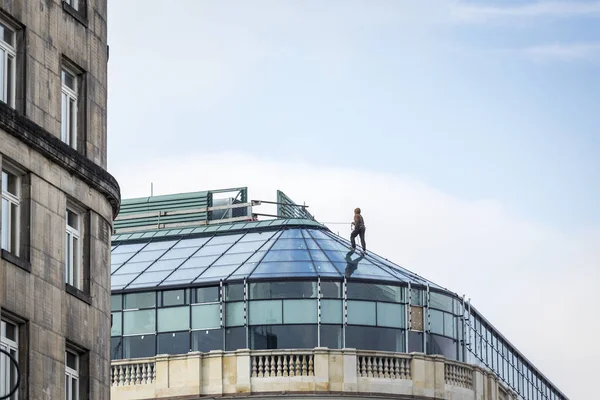 Werknemer in harnas op glazen gebouw — Stockfoto