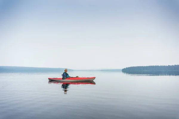 Mujer en gafas de sol disfrutando del lago de kayak rojo —  Fotos de Stock