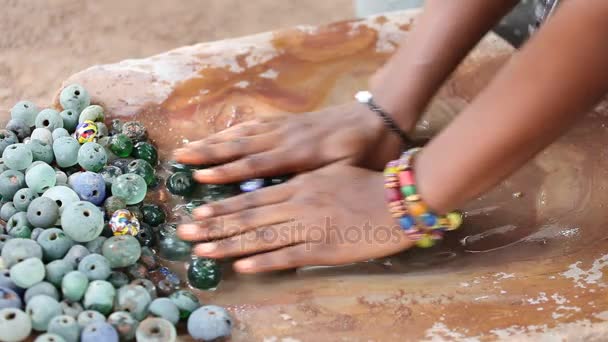 Ruční čištění skleněné korálky k výrobě, Ghana, — Stock video