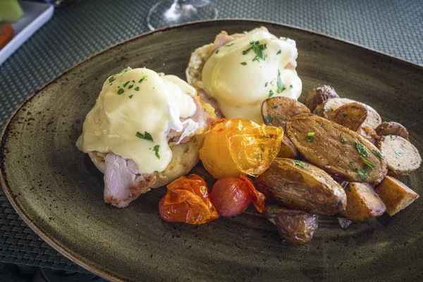 Benedict Eggs lezat disajikan dengan kentang panggang dan tomat — Stok Foto