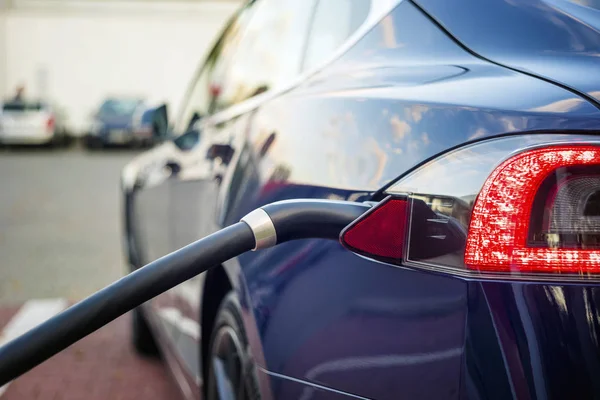 Moderne elektrische auto die zijn aangesloten op het laadstation. — Stockfoto