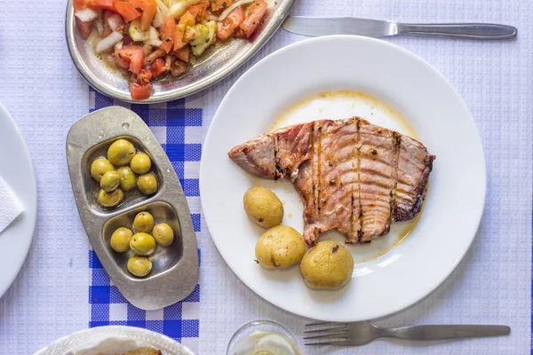 Bistecca di tonno accompagnata da patate, olive, insalata di pomodoro e w — Foto Stock