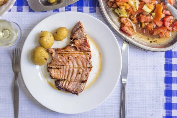 Bistecca di tonno accompagnata da patate, olive, insalata di pomodoro e w — Foto Stock