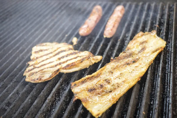 Slanina, kuřecí prsíčka a čerstvé klobásy grilované dohromady — Stock fotografie