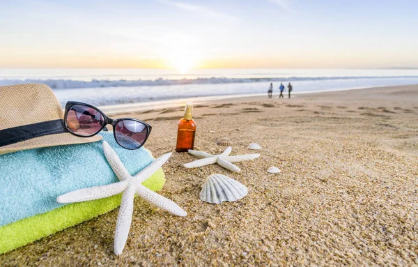 Óculos de sol, toalhas, chapéu, protetor solar, conchas e estrelas do mar em arenoso — Fotografia de Stock