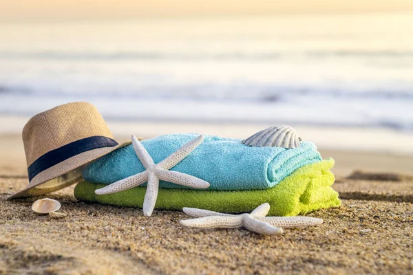 Zonnebril, handdoeken, hoed, zonnebrandcrème, schelpen en zeesterren op sandy — Stockfoto