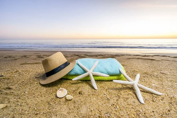 Óculos de sol, toalhas, chapéu, protetor solar, conchas e estrelas do mar em arenoso — Fotografia de Stock