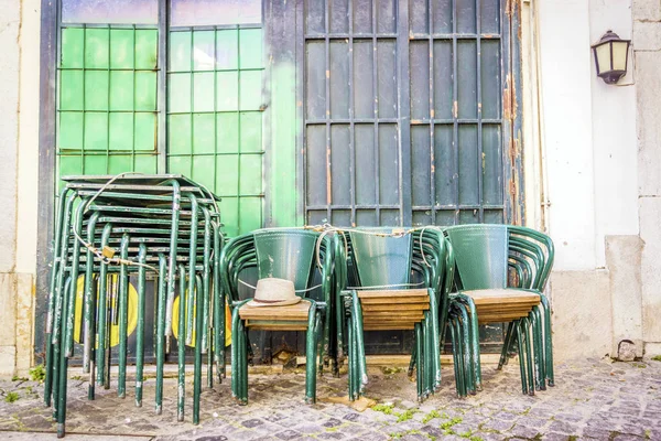 Mesas y sillas verdes apiladas en la calle Lisboa, Portugal —  Fotos de Stock