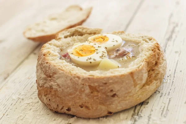 Traditional polish soup called Zurek served in small bread — Stock Photo, Image