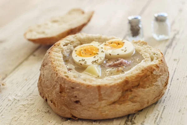 Traditional polish soup called Zurek served in small bread — Stock Photo, Image