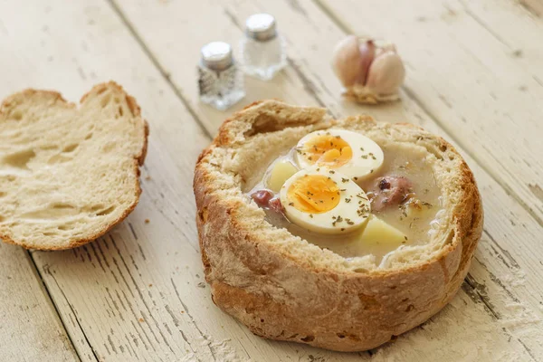 Traditional polish soup called Zurek served in small bread — Stock Photo, Image