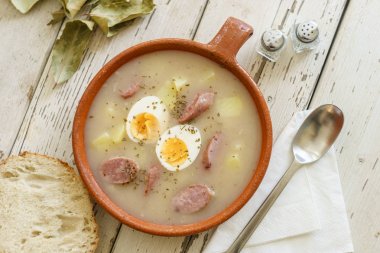 Zurek olarak adlandırılan geleneksel Lehçe çorba ekmek ile servis
