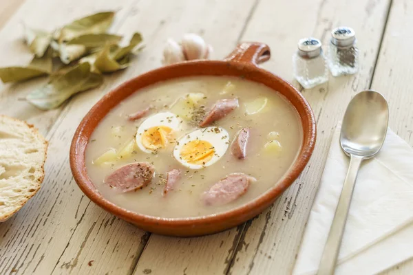 Traditional polish soup called Zurek served with bread