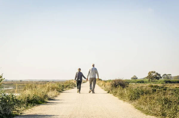 Couple de personnes âgées amoureux marchant sur une route poussiéreuse, Portugal — Photo