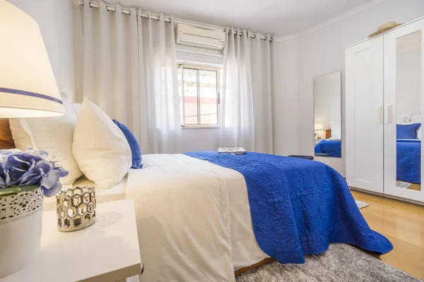 Um elegante quarto arranjado em branco e azul com a luz acesa — Fotografia de Stock