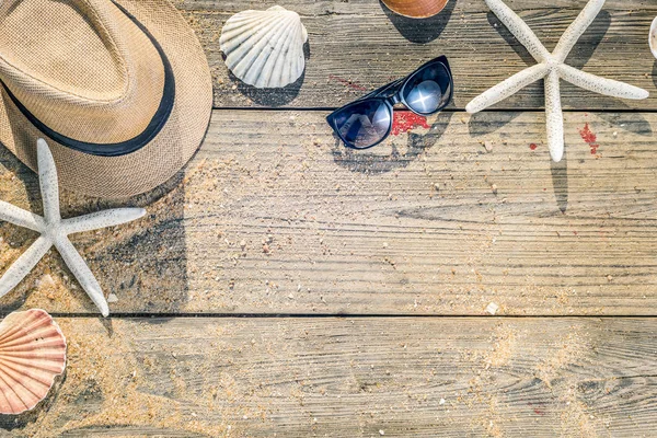 Καλοκαίρι καπέλο, κοχύλια και ήλιο γυαλιά σε ξύλινο και αμμώδης backgroun — Φωτογραφία Αρχείου