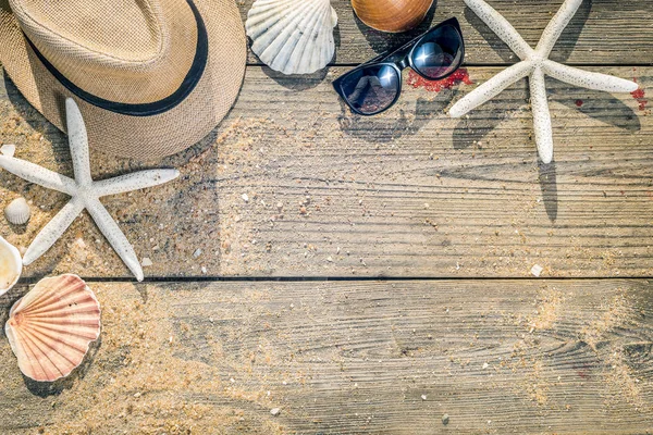 Sommaren hatt, skal och sol glasögon på trä och sandstranden bak — Stockfoto