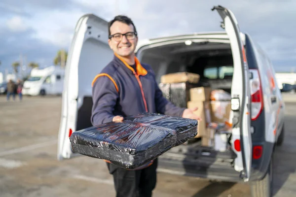 Bezorger deelt een pakje uit — Stockfoto