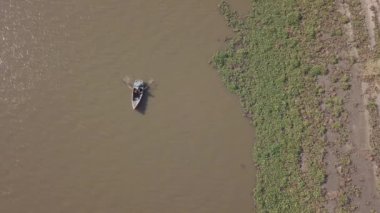 Balıkçı, Mozambik 'teki Macaneta Sahili, Incomati Nehri' ndeki teknesinde yuvalarıyla kürek çekiyor.