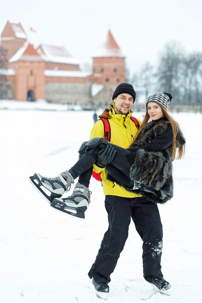 Young girl and fellow at rink in winter Trakai