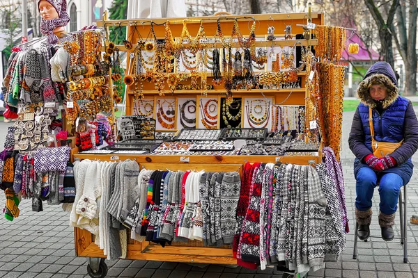 Donna vicino al suo chiosco con diversi souvenir nella vecchia Riga — Foto Stock