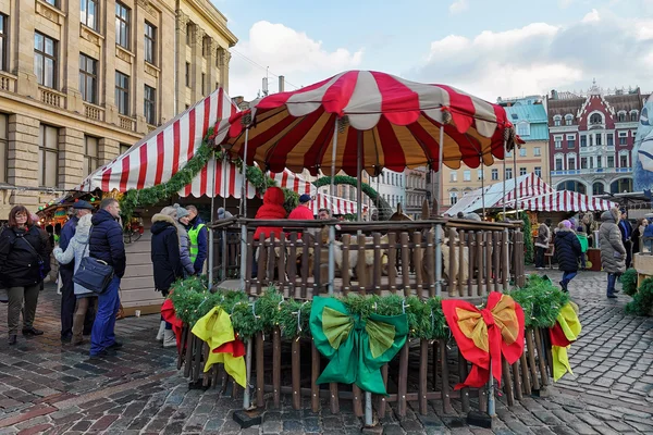 Mensen bij carousel op Riga kerst markt op het Domplein — Stockfoto